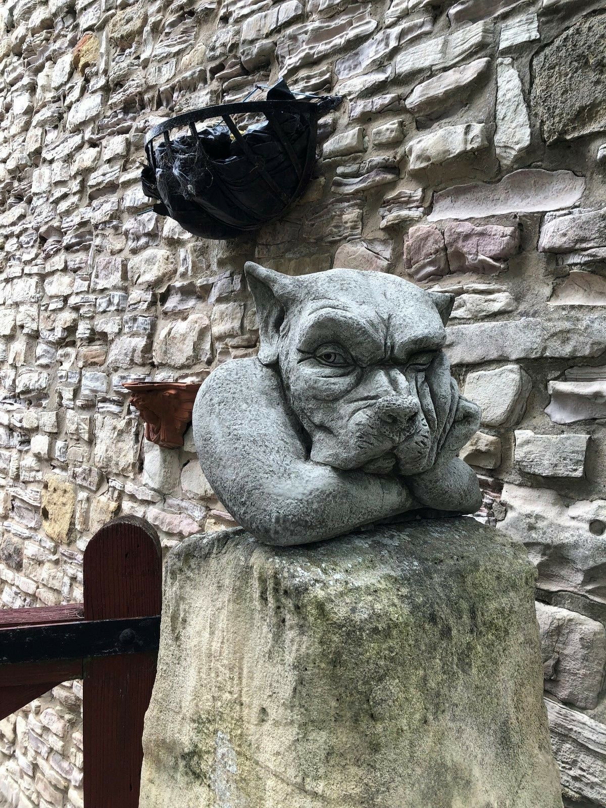 Gargoyle Dog Finial - Stone Garden Ornament resting on a stone pillar, showcasing its large, durable design for outdoor use.