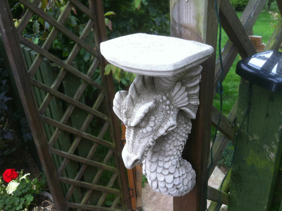 Angled top view of antique stone Dragon Wall Shelf on trellis. Sturdy garden plaque for hanging on fences or outdoor walls.