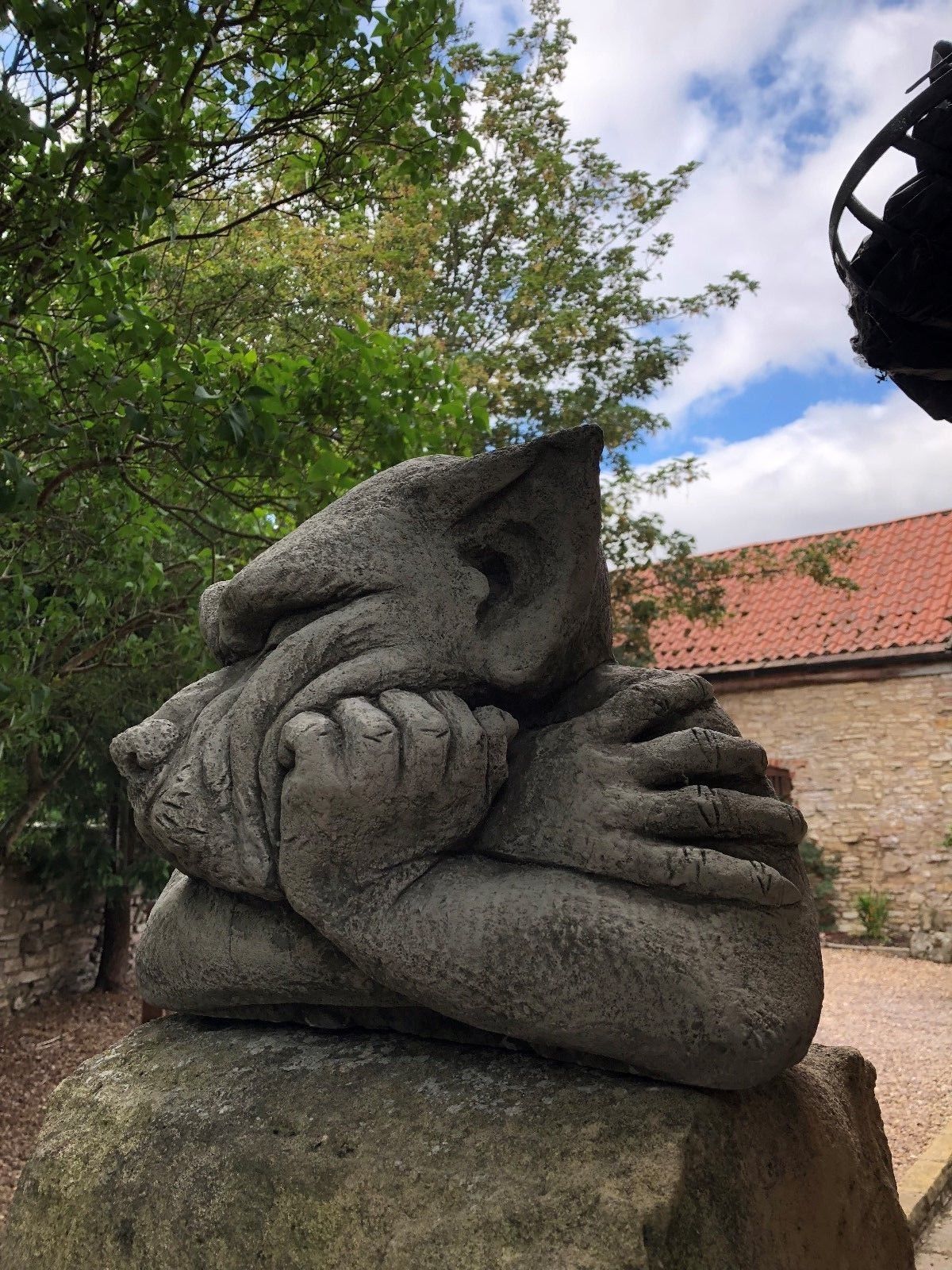 Side angle of Gargoyle Dog Finial - Stone Garden Ornament showing its expressive pose and solid stone craftsmanship.