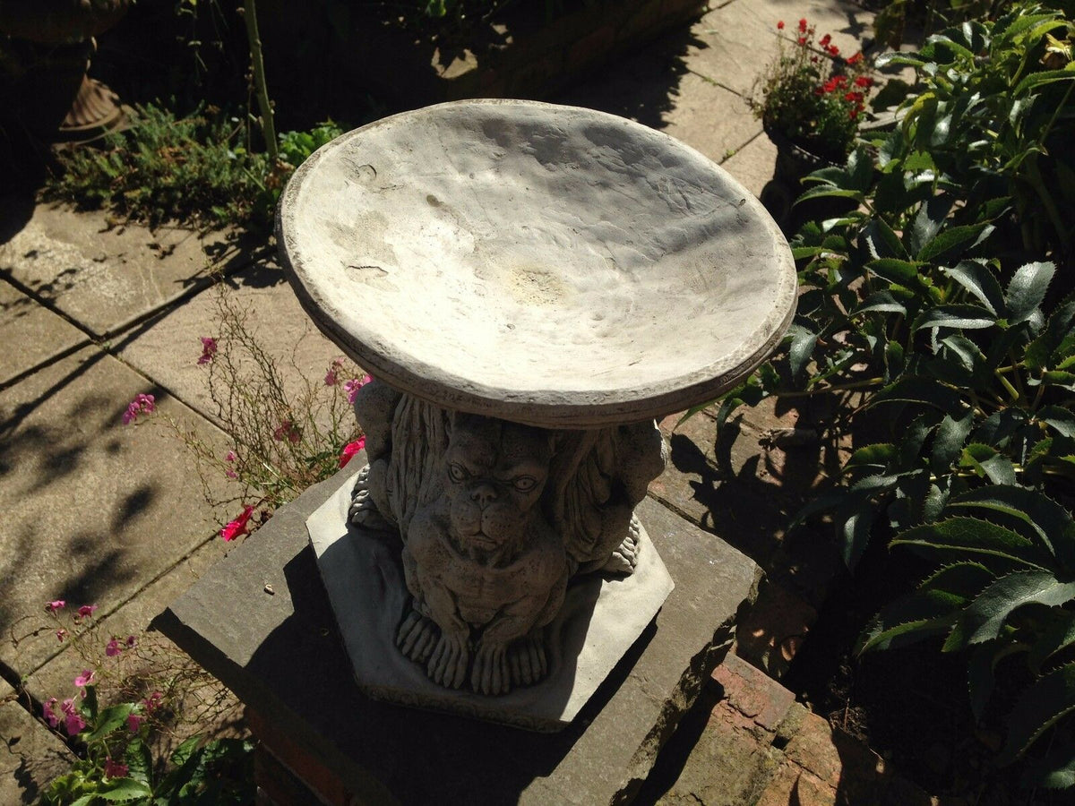 Close-up of Garden Bird Bath - Stone Gargoyle Design showing textured limestone basin and sculpted gargoyle base in outdoor setting.