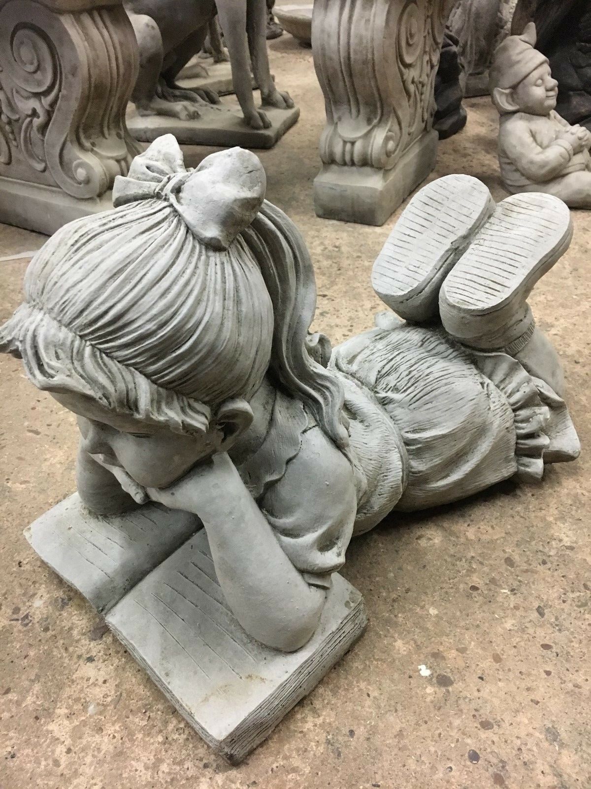 Side profile of Reading Girl Garden Statue in stone finish, perfect for outdoor decor with realistic book and child features.