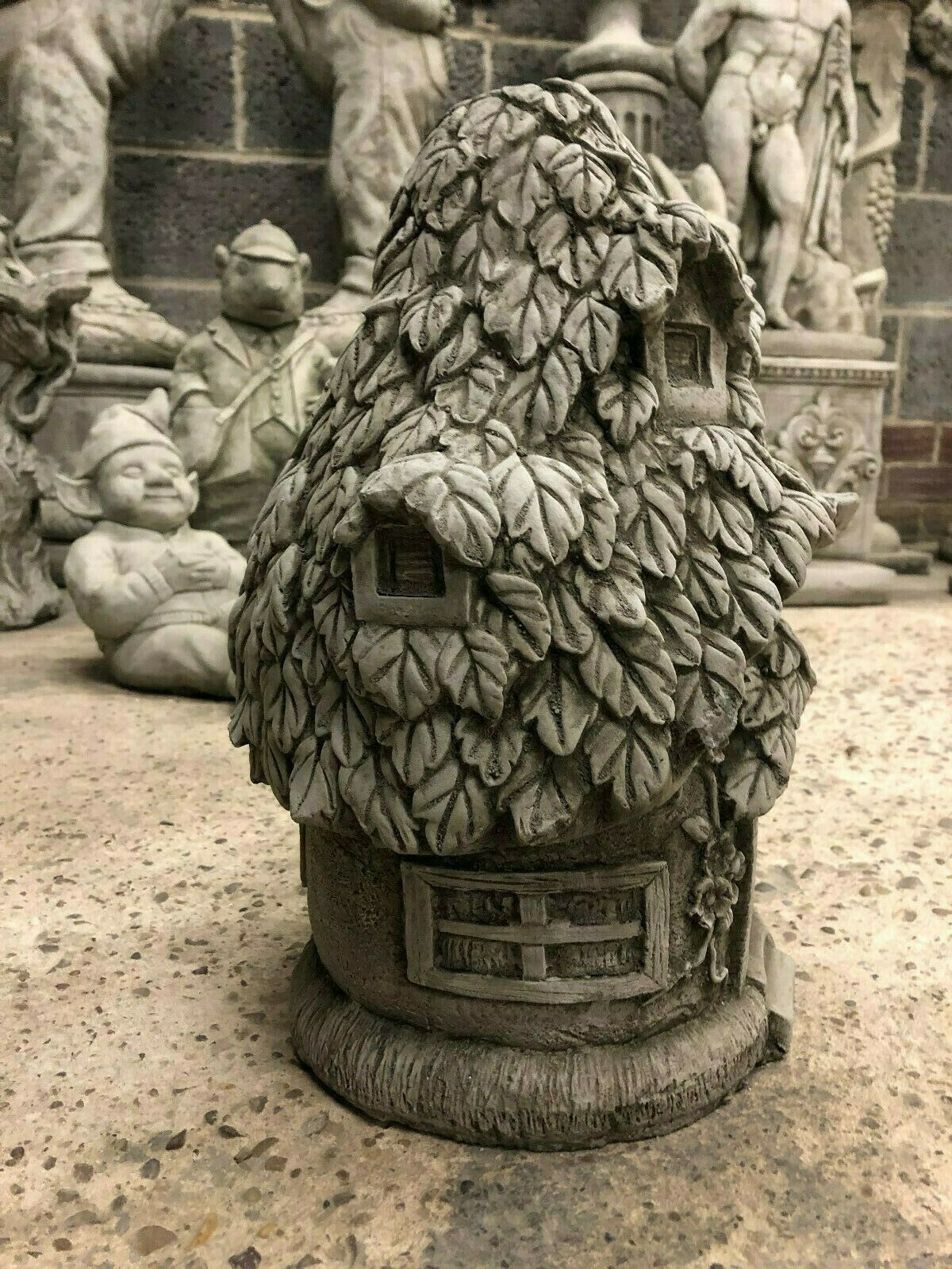 Angled side view of Stone Ivy Cottage Ornament - Stone Garden Ornament, showcasing intricate ivy detailing and multiple windows.