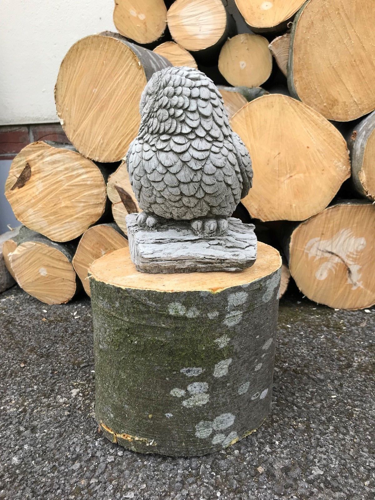 Rear angle of baby owl statue made from limestone. Weather-resistant garden ornament with detailed feather design.
