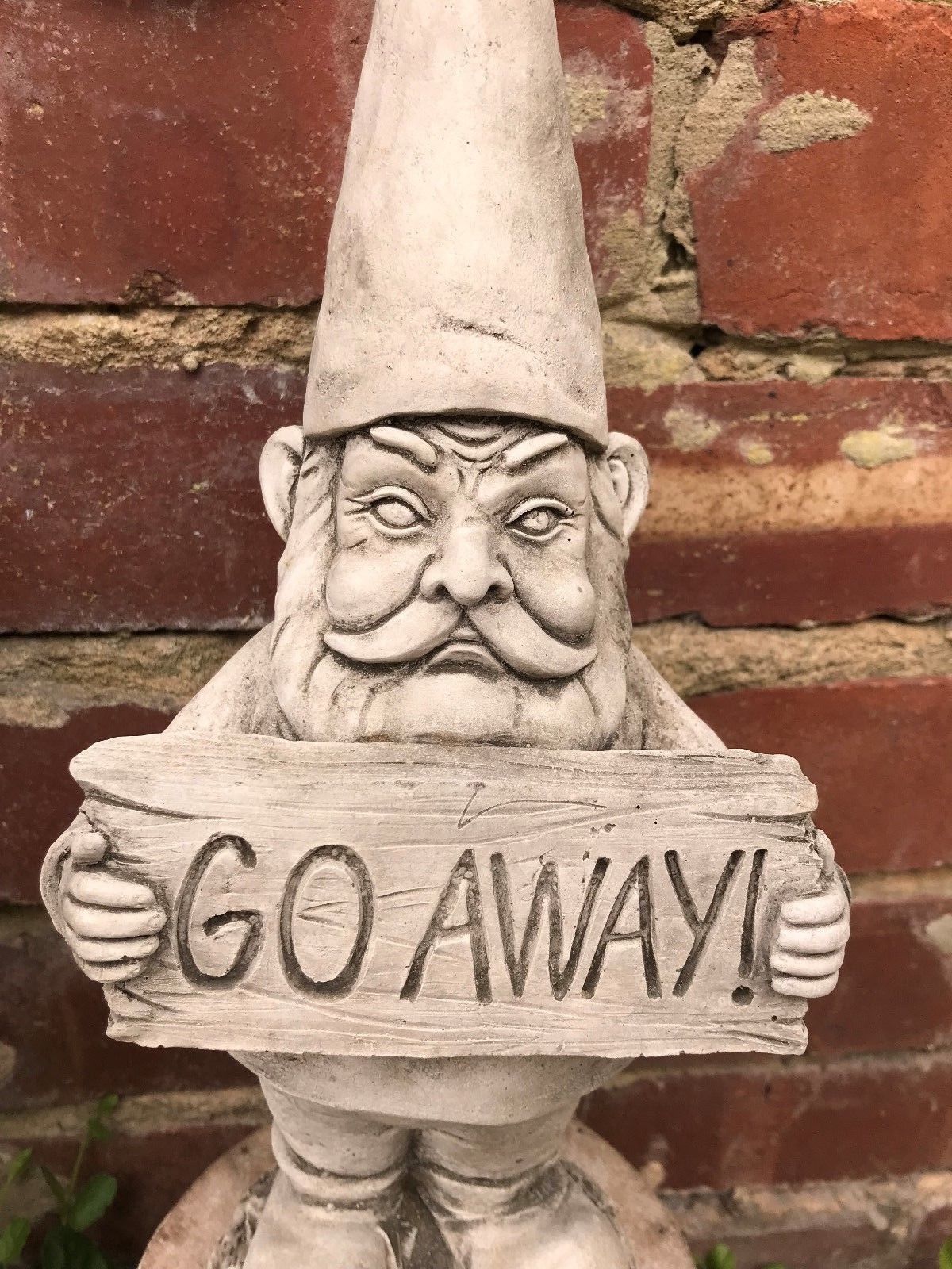 Close-up of the Grumpy Garden Gnome holding a 'GO AWAY!' sign, showcasing intricate stone carving and humorous garden decor style.