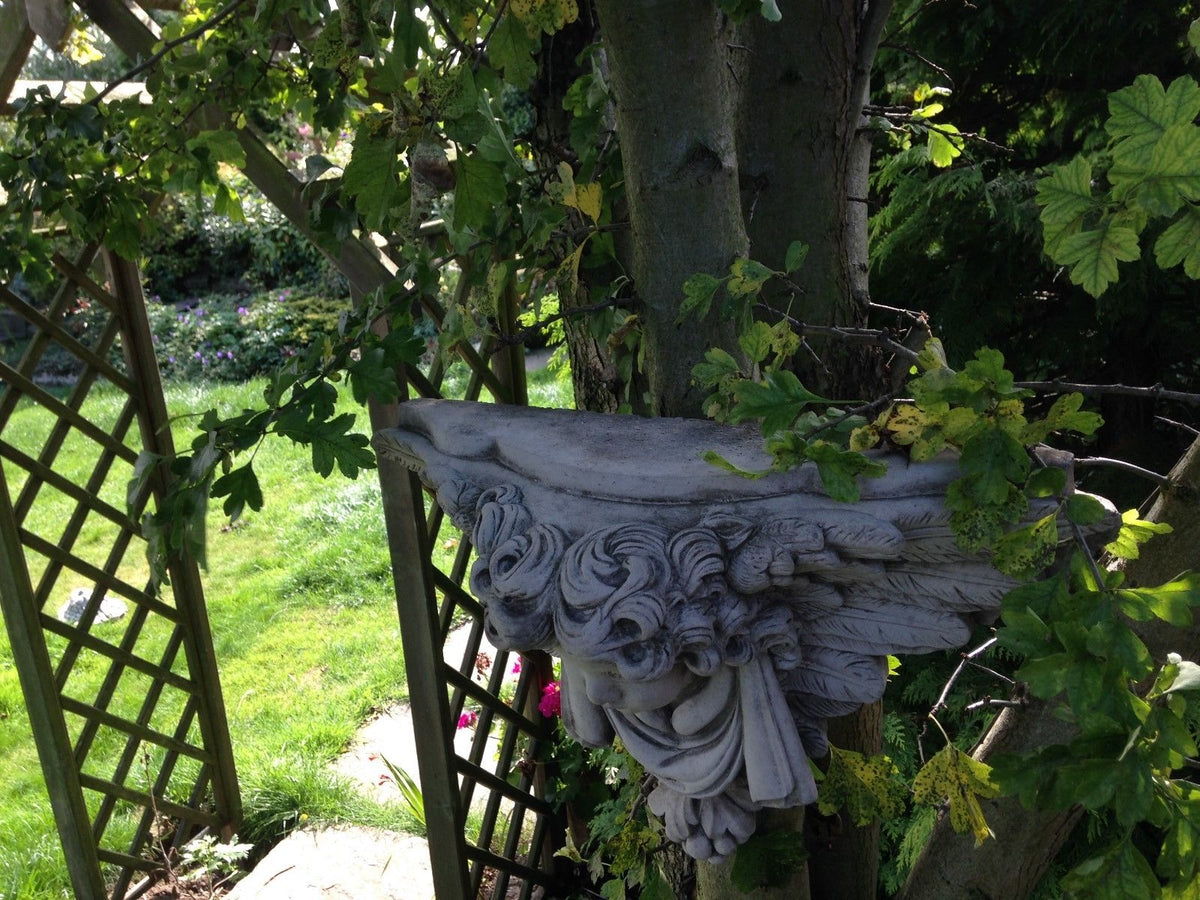 Angled view of Stone Cherub Garden Wall Shelf highlighting its depth and sculpted features. Easy to hang on trees or walls for outdoor garden decoration.