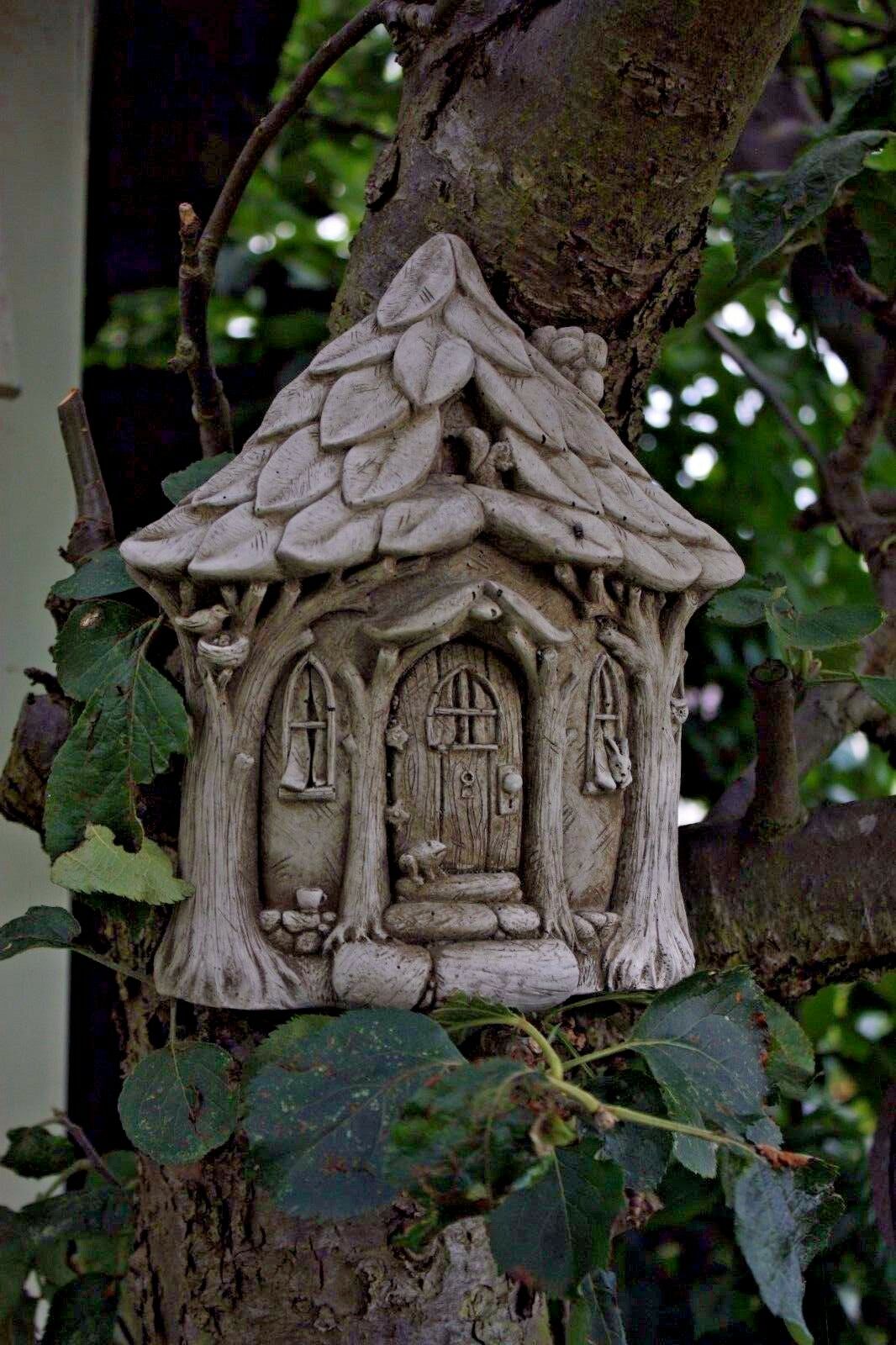 Close-up of Stone Fairy Garden House plaque on tree trunk, showing detailed limestone design. Perfect for whimsical garden wall or tree decoration.