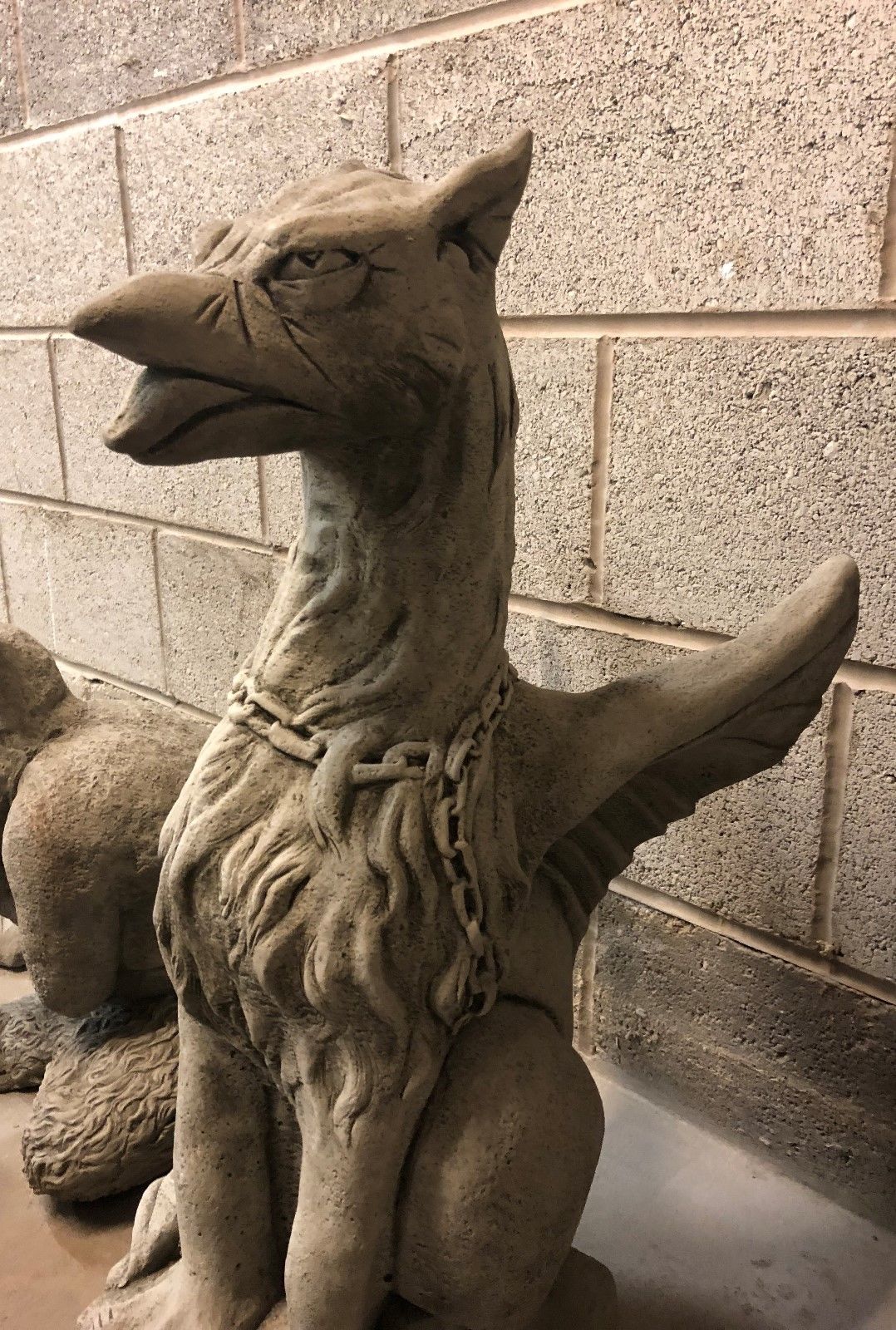 Side profile of stone phoenix statue showing sharp beak and wing detail, crafted for outdoor garden sculpture collections.