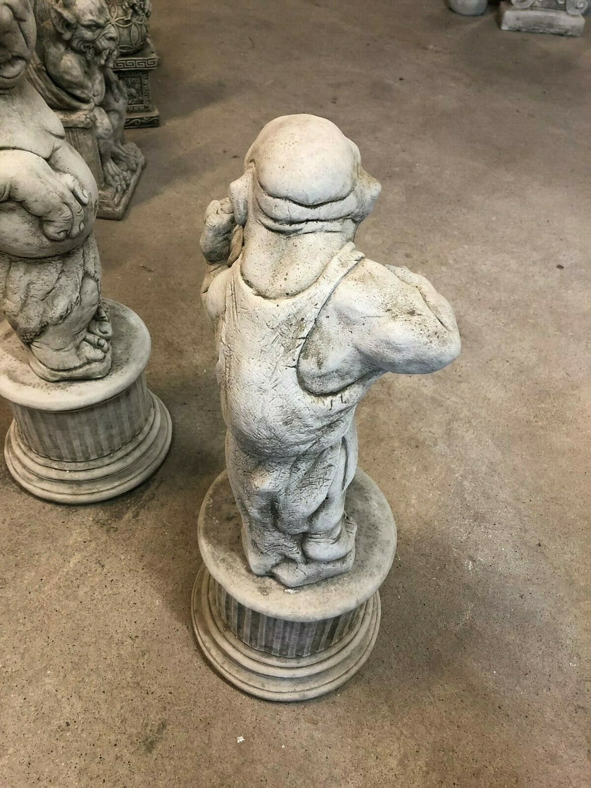 Rear view of stone garden statue depicting a muscular boxer in overalls, ideal for quirky garden sculpture displays.