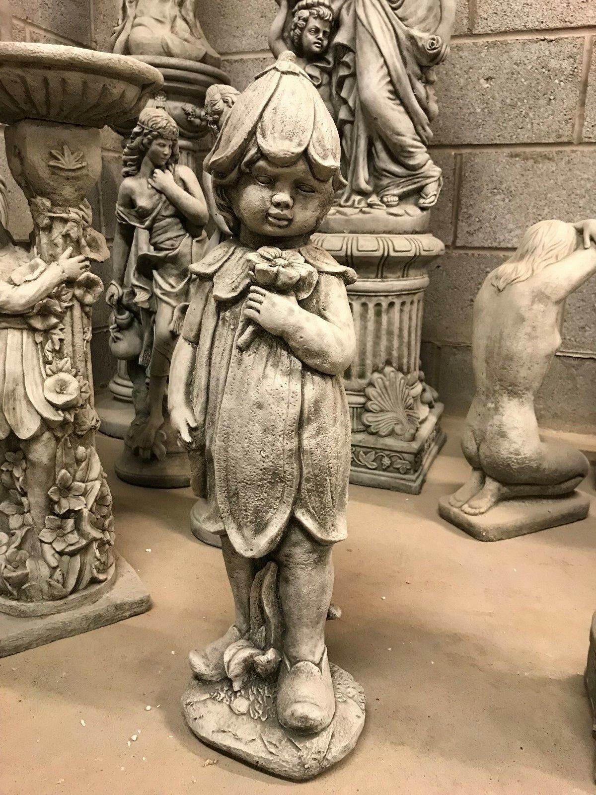 Stone Bluebell Girl Statue in a flower-themed dress, ideal for garden decor. Durable limestone sculpture adds charm to outdoor spaces.