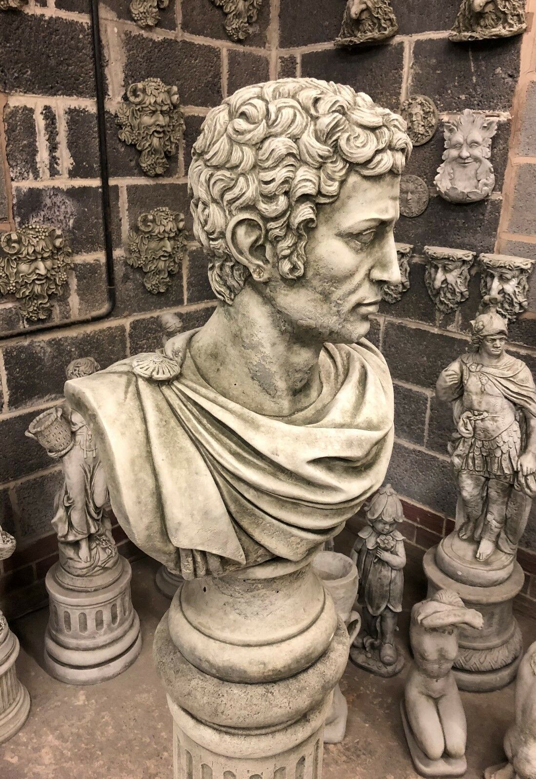Close-up side profile of Stone Marc Anthony Bust Statue, highlighting detailed curls and toga folds on a limestone Roman pedestal.